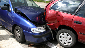 Two cars with front-end damage in a collision, one blue and one red.